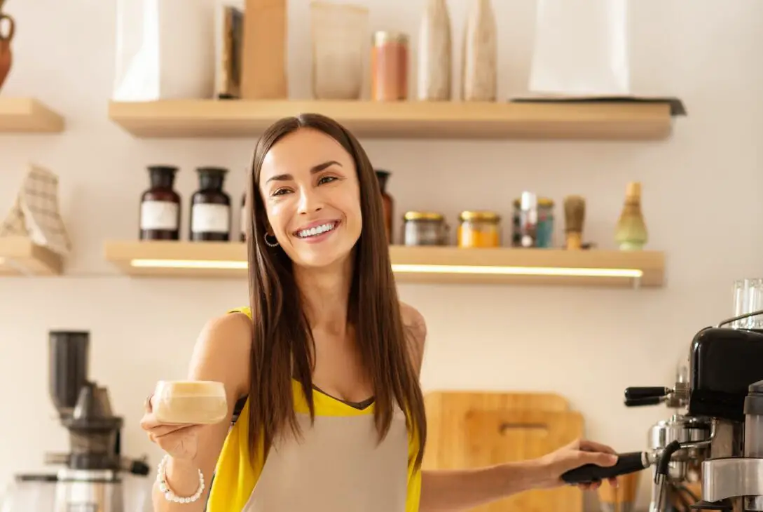 Barista smiling while talking to customer and making coffee