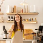 Barista smiling while talking to customer and making coffee