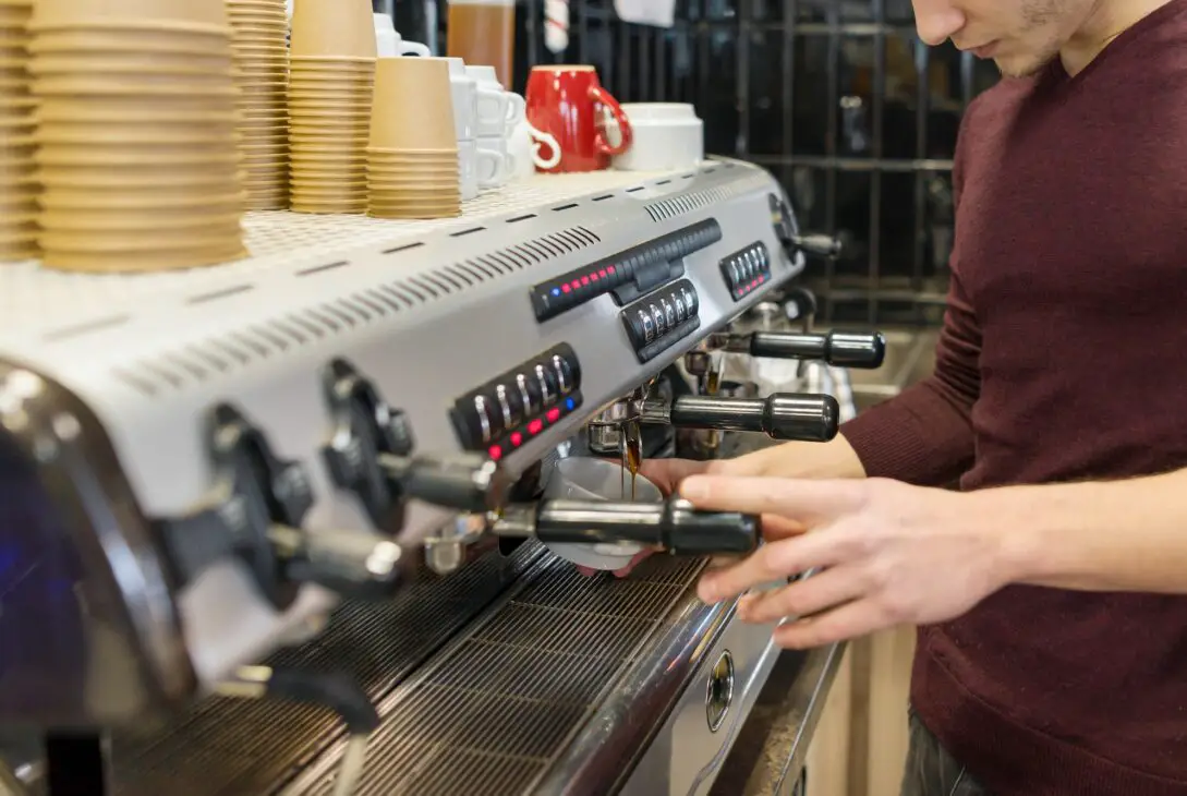 Closeup of coffee making process, hands of barista using a coffee machine