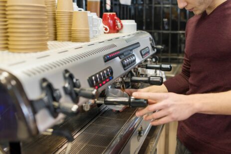 Closeup of coffee making process, hands of barista using a coffee machine