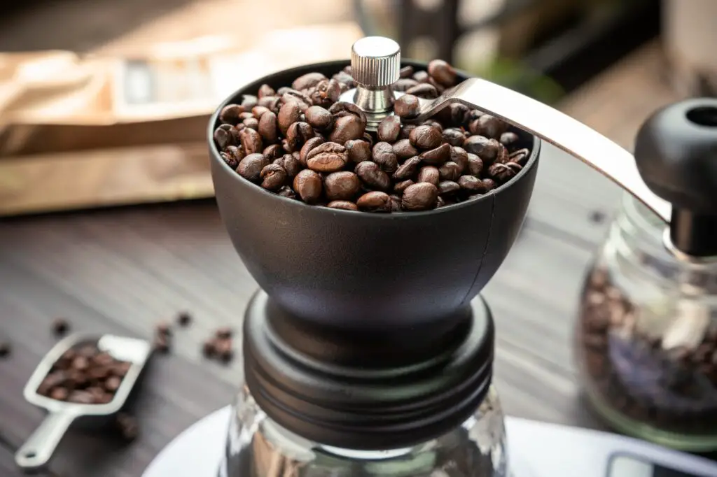 Coffee beans roasted in a manual coffee grinder. How to choose the best coffee grinder.