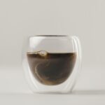 Swirls of milk in Double Walled Glass with coffee on white background